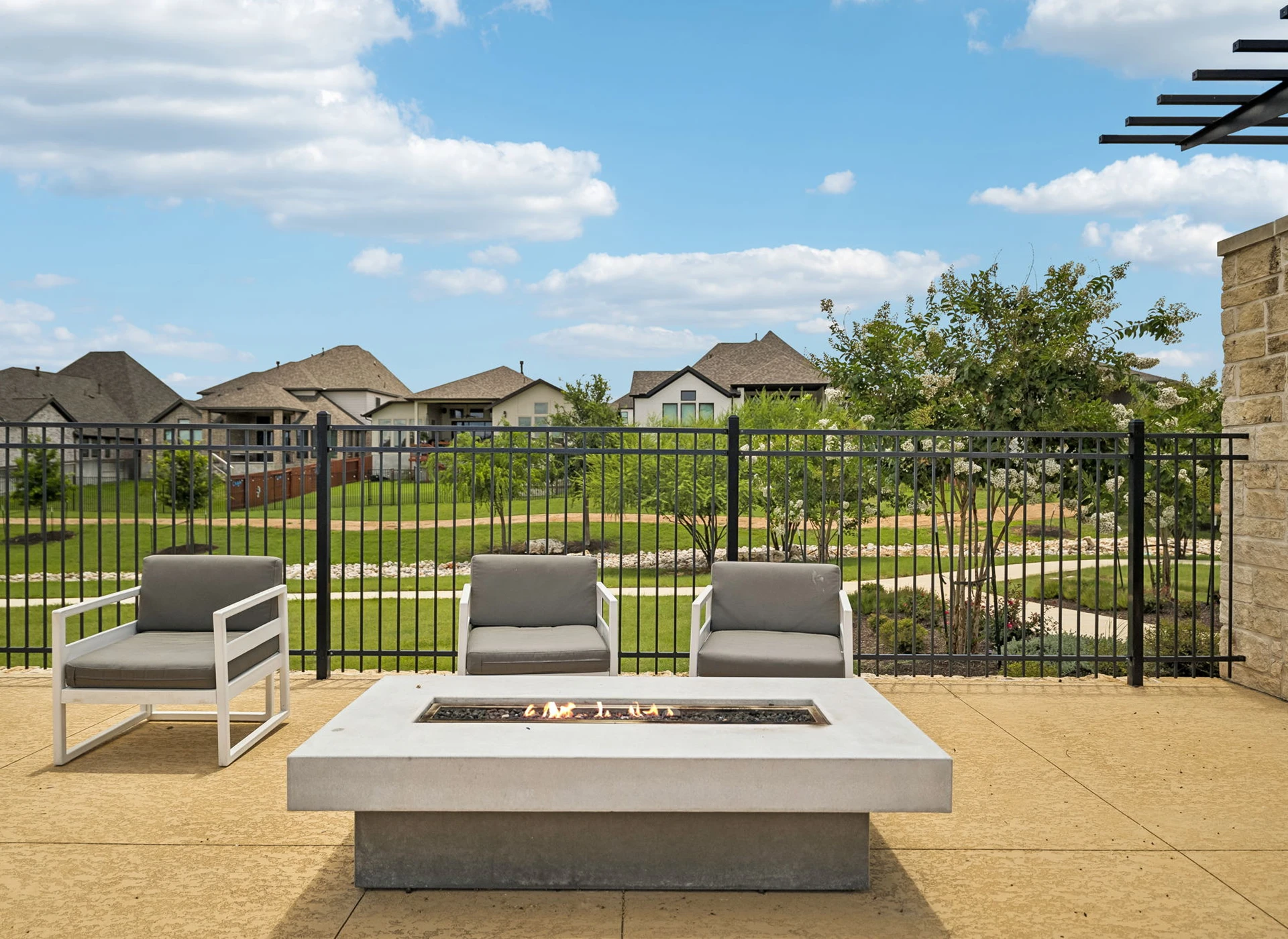 Outdoor patio with fire pit and chairs.