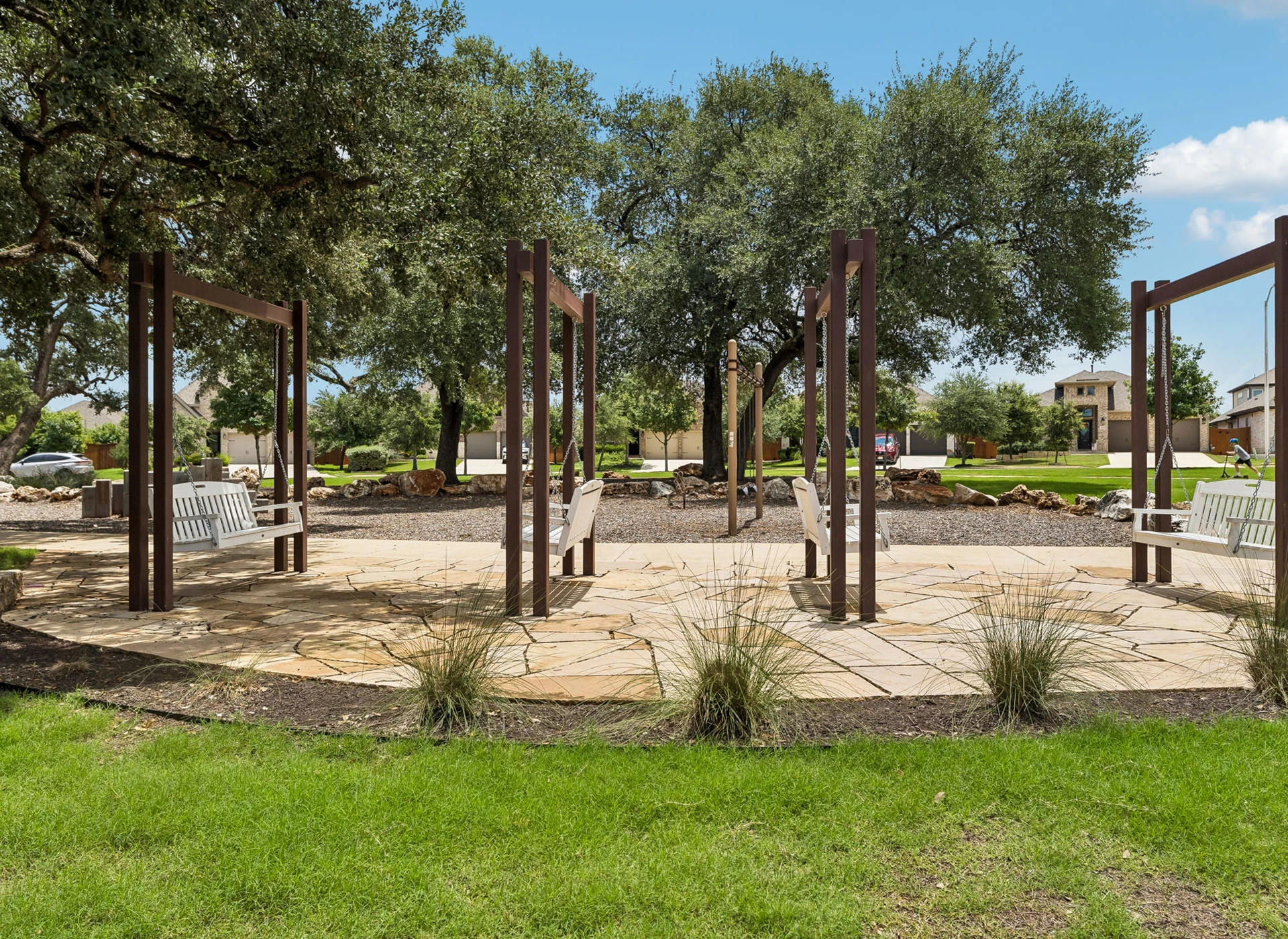 Park seating area with trees and grass.