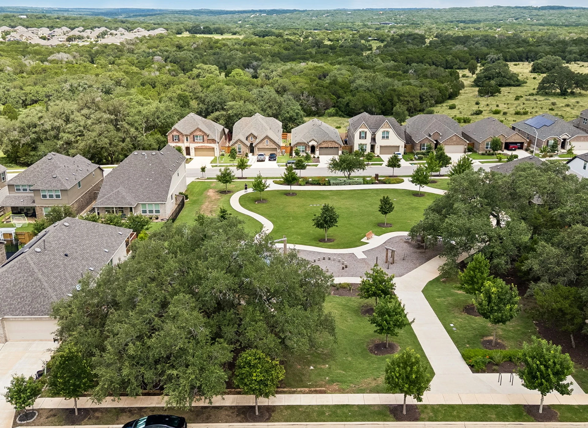 Suburban neighborhood with park and houses.