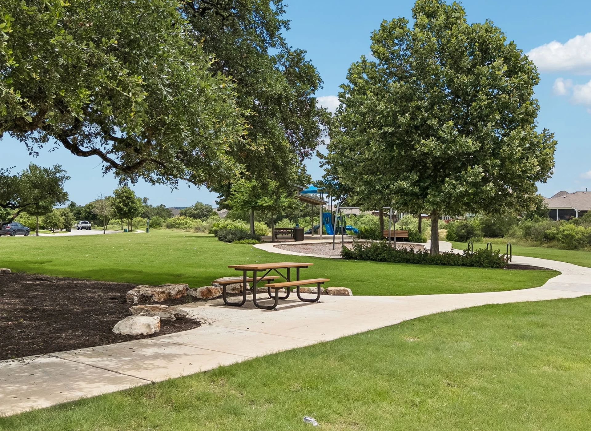 Park with picnic table and playground equipment.