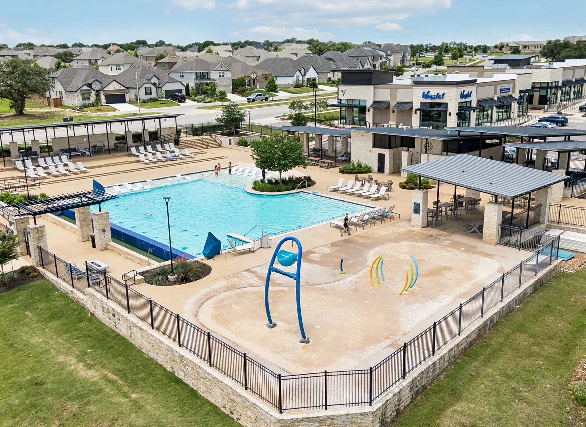 Community pool with adjacent splash pad area.