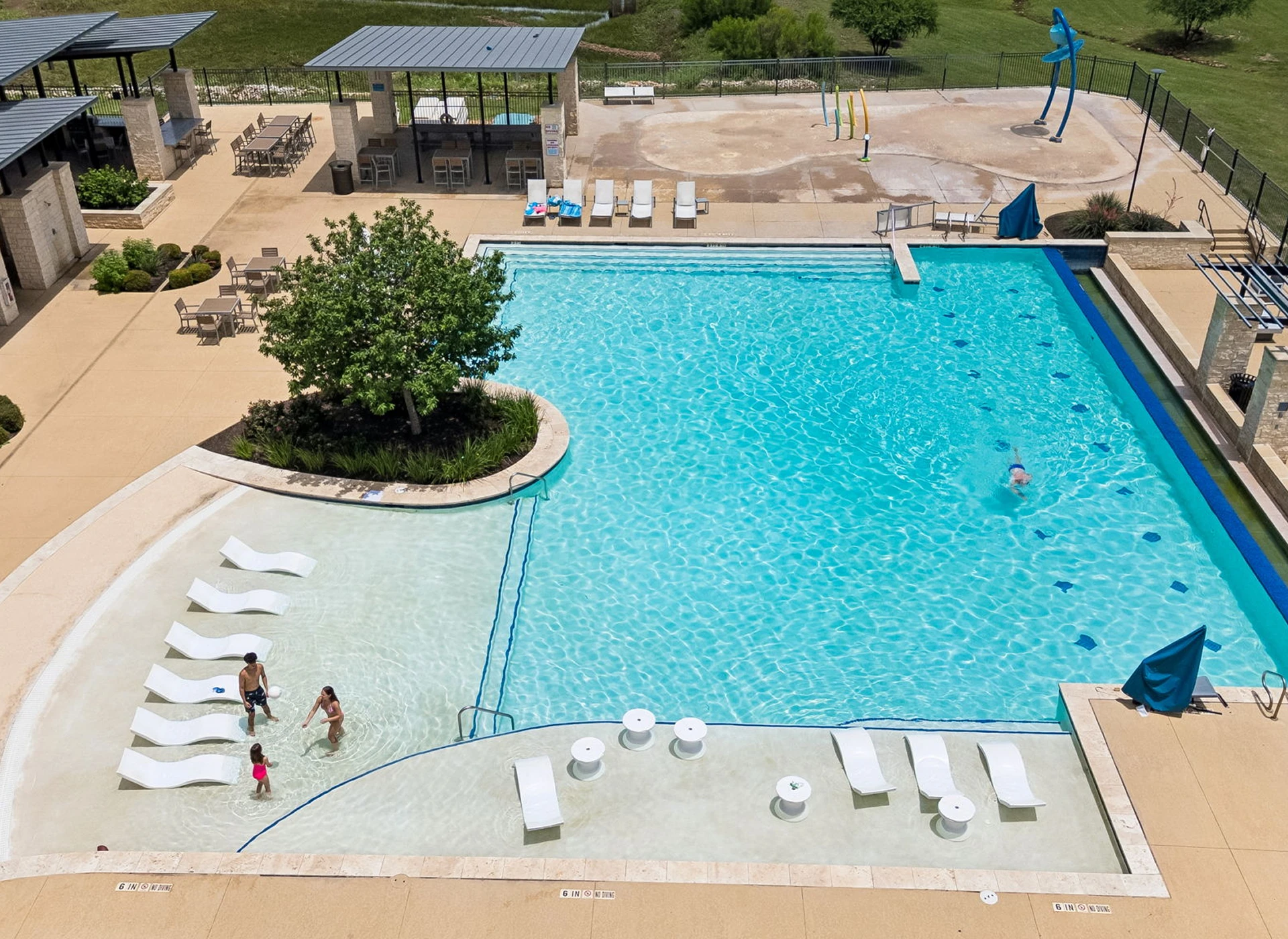 Outdoor pool with lounge chairs and pavilion.