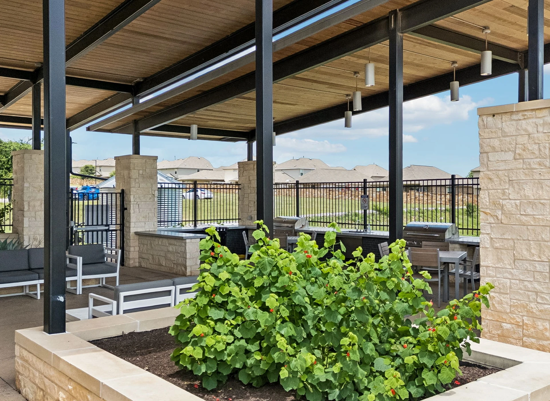 Outdoor patio with seating and green plants.
